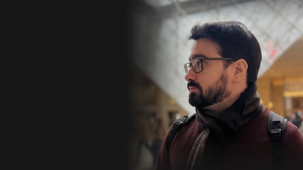 João Pedro Staffa Carvalho de perfil, sob a pirâmide do Louvre, em Paris